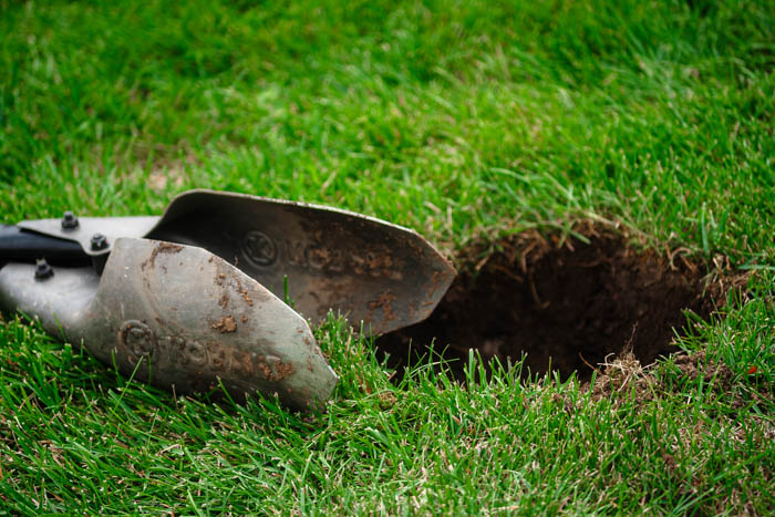 post hole digger in grass for install mailbox post